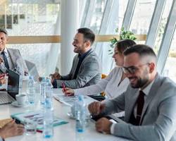 A group of people meeting at a conference table to discuss ship chartering.